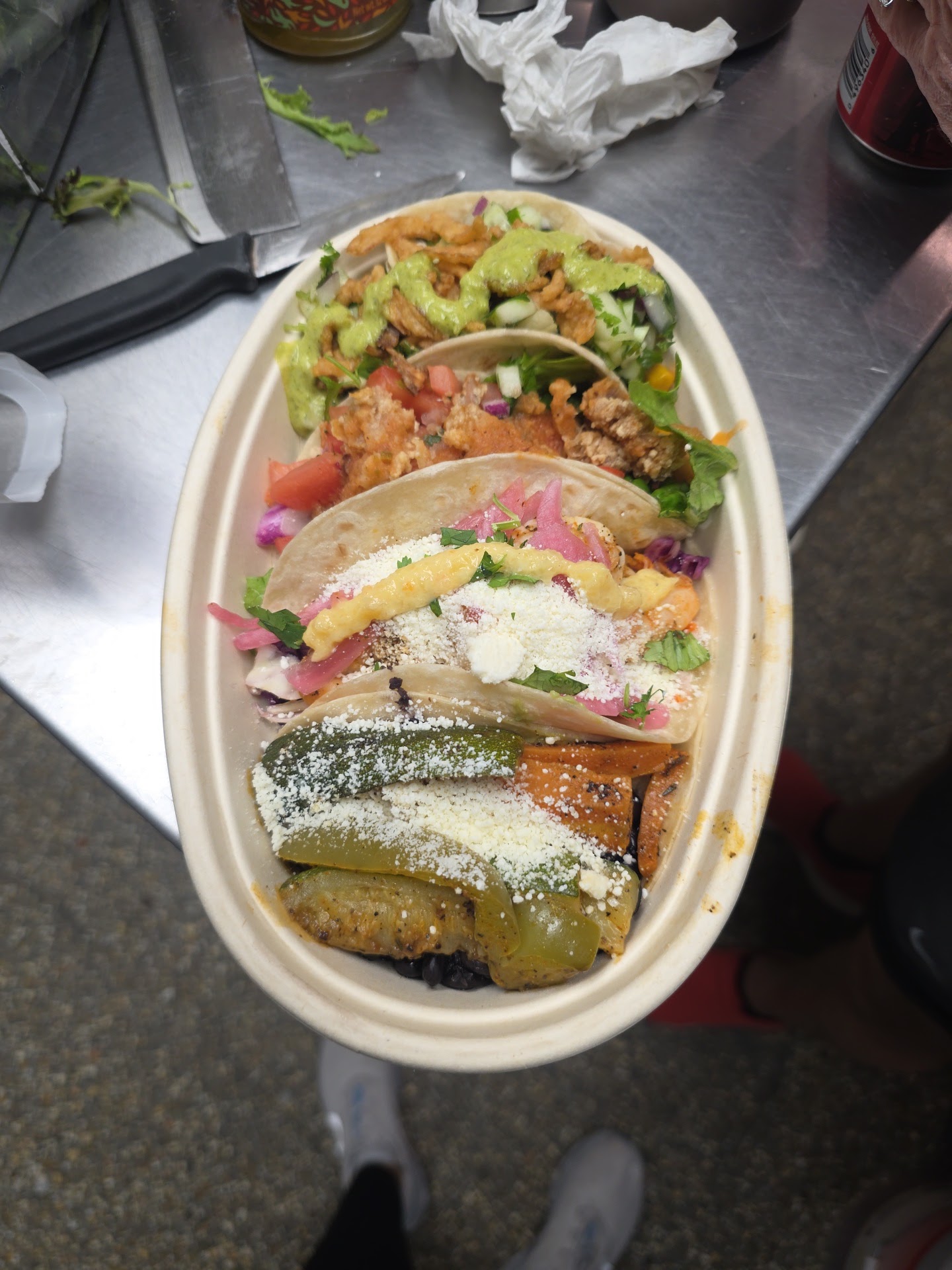 Four loaded tacos in a takeout tray at Two Chicks Tacos